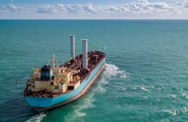 Large boat carrying containers on the sea.
