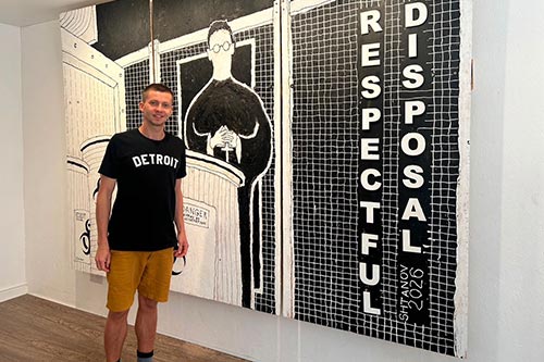 Mark standing in front of one of his paintings