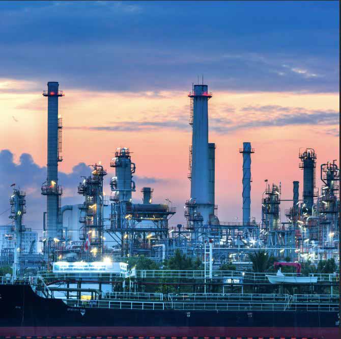 A refinery lit up, at sunset