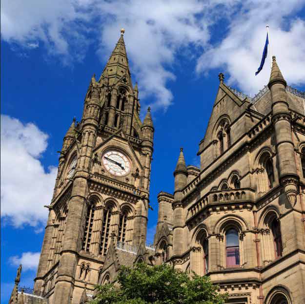 a photograph taken looking up at the clock tower of Manchester Town Hall