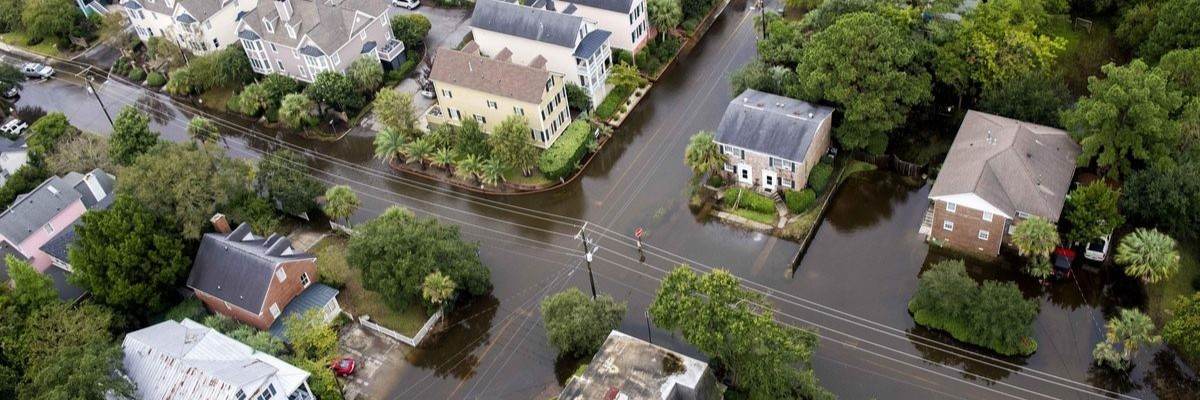 Flooded suburban streets and houses surrounded by water after heavy rainfall.